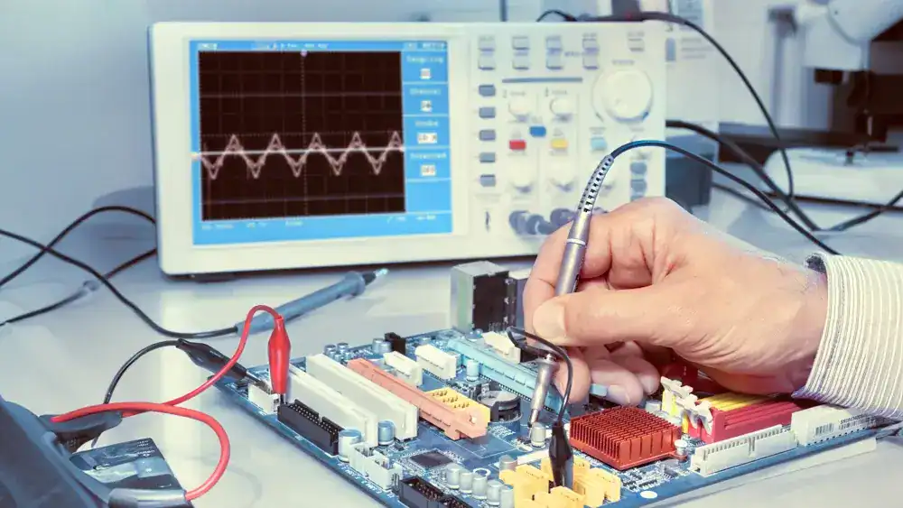 lab tech using electronic test equipment on electronic board