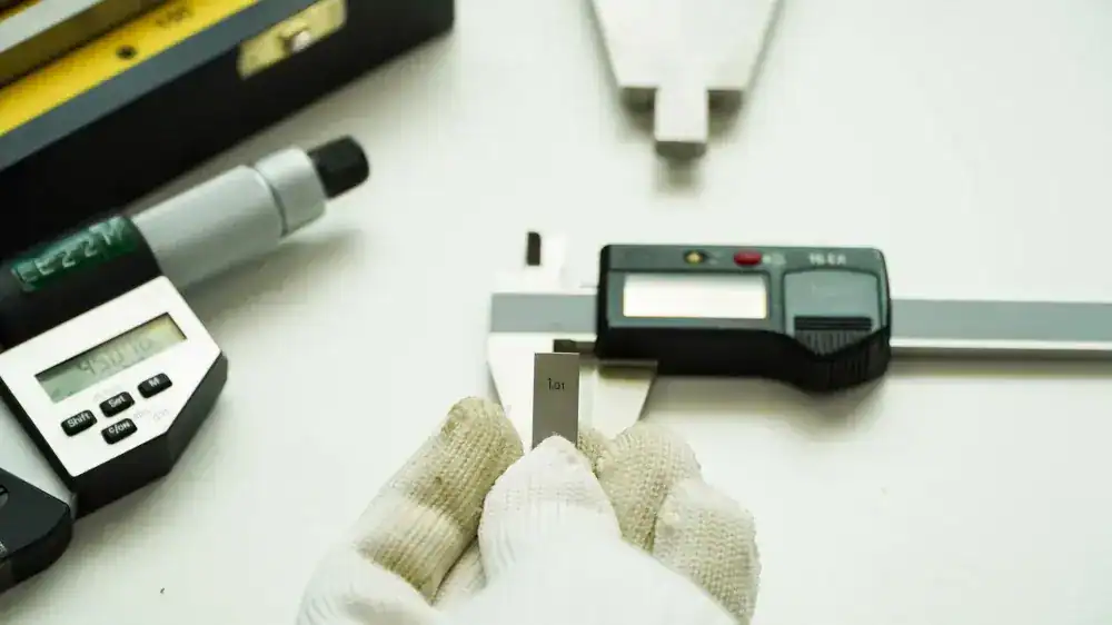lab tech calibrating a caliper using a gage block